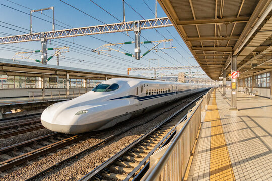 Tokyo, Japan - December 29, 2025:  White Shinkansen bullet train passing through Tokyo Train Station at high speed.