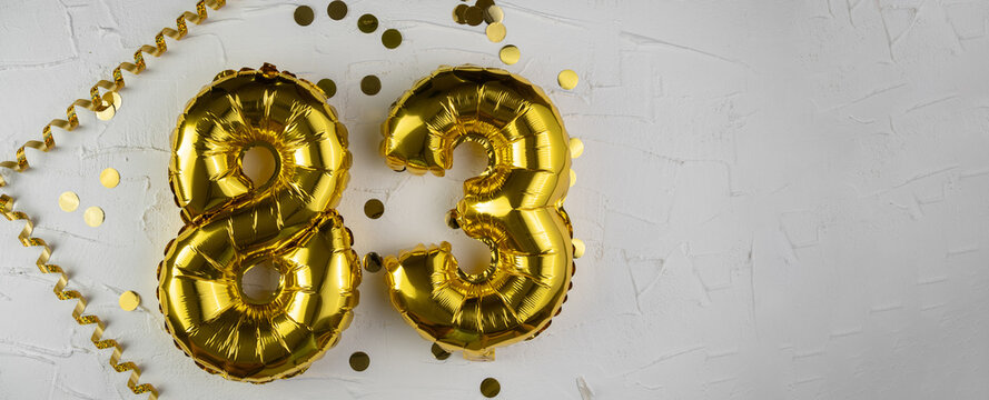 Yellow Gold foil balloon number eighty-three on white background. Birthday card with lettering 83. Anniversary concept. For anniversary, birthday, wedding event, new year celebration.