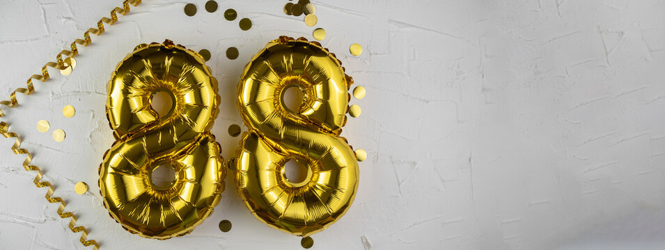 Yellow Gold foil balloon number eighty-eight on white background. Birthday card with lettering 88. Anniversary concept. For anniversary, birthday, wedding event, new year celebration.