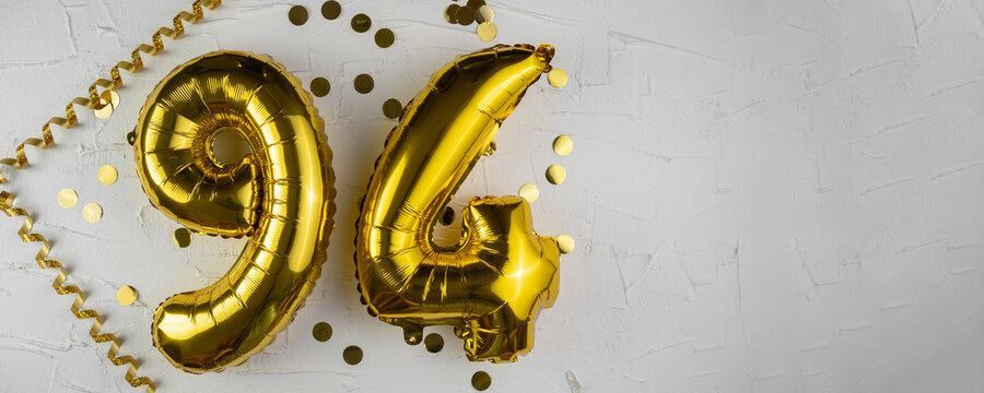 Yellow Gold foil balloon number ninety-four on white background. Birthday card with lettering 94. Anniversary concept. For anniversary, birthday, wedding event, new year celebration. Banner
