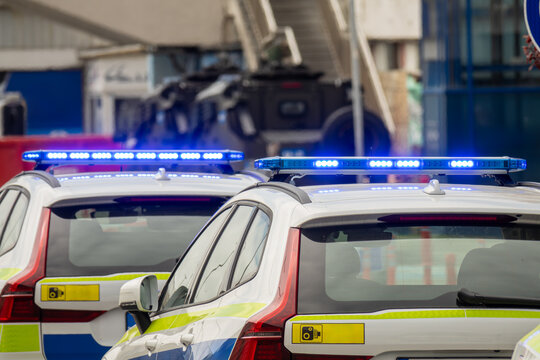 Police Patrol Cars with Flashing Blue Emergency Lights on Urban Street, Law Enforcement Response