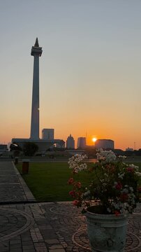 Jakarta, Indonesia - July 16, 2026: Sunset at the National Monument (Monas) in Jakarta, with a view of high-rise buildings. Vertical video.