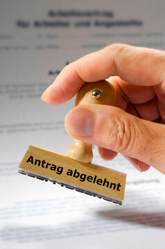 Eine Hand h&auml;lt einen Holzstempel mit der Aufschrift - Antrag abgelehnt