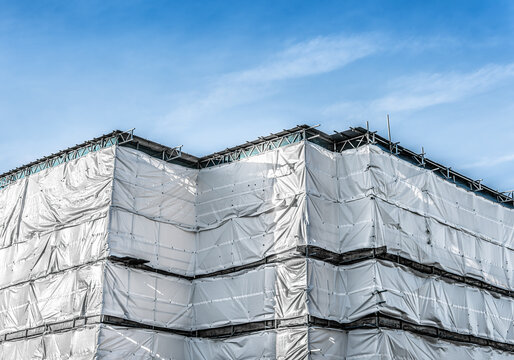 New modern building construction project with safety netting for scaffold