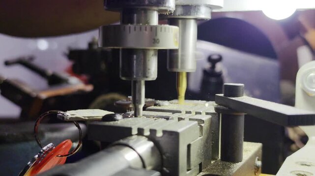 Close-up of a locksmith duplicating an original metal key, precisely milling matching grooves into a new key blank with selective focus, highlighting professional security and replacement services.