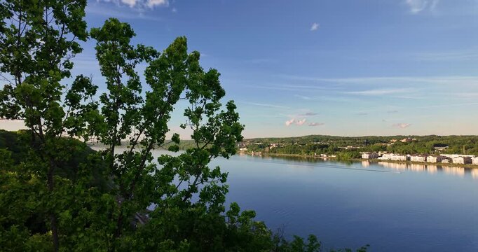 High angle view of the Hudson River surrounded by lush green forested banks under a blue sky in Poughkeepsie New York
