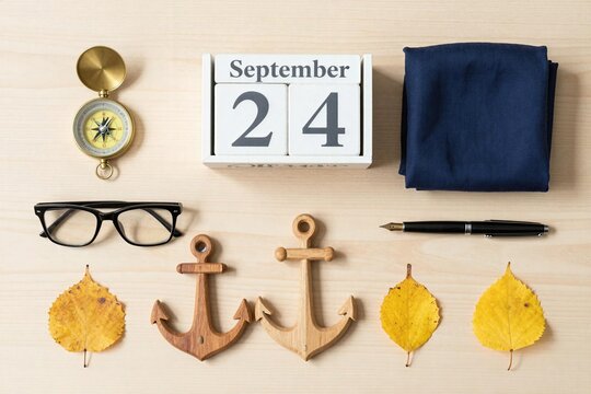Items arranged on a wooden surface showing September 24 with anchors and leaves