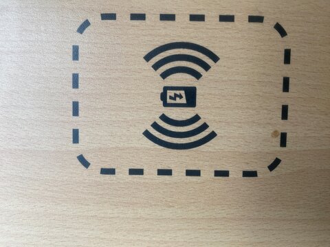 Symbol f&uuml;r kabelloses induktives Laden eines Smartphones im Zug. Moderne Mobilit&auml;t, WLAN, Regionalbahn, ICE, &ouml;ffentlicher Nahverkehr, Reisen und digitale Konnektivit&auml;t.