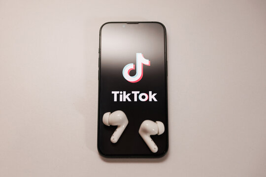 Bălți, Republic of Moldova - July 20 2026: TikTok app logo on smartphone screen and wireless earbuds, mobile social media entertainment and audio listening concept