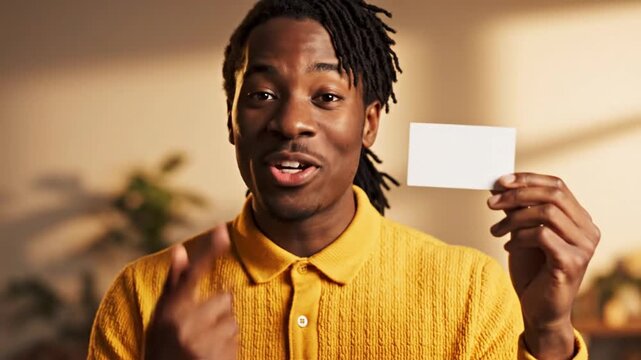 Happy young Black man holding blank white card