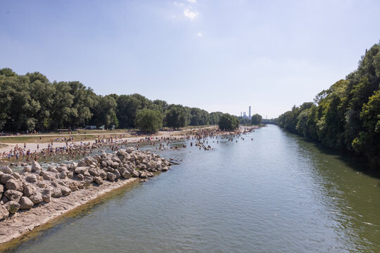People cooling off in a river in the middle of a city on a hot day. Munich, Germany