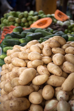 Batatas, cebolas e hortali&ccedil;as frescas expostas em feira livre, destacando produtos agr&iacute;colas da culin&aacute;ria brasileira em mercado popular tradicional.