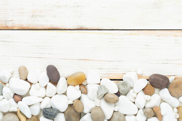 White pebble stones on wooden background, top view © Liami
