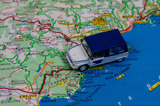 Miniature toy Citro&euml;n M&eacute;hari-style van positioned on a road map over the Cannes and Est&eacute;rel coastal area, with the &Icirc;les de L&eacute;rins visible nearby.