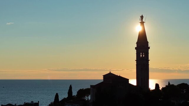Aerial View of Church Bell Tower Silhouette Against Bright Golden Sunset Sky