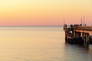 Fototapeta premium People watching sunset from sea pier