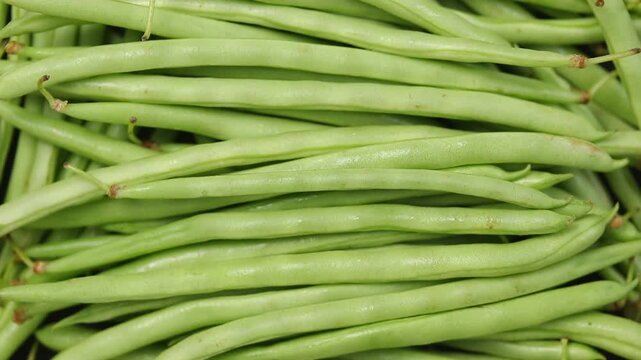 Pile of raw needle bean or baby french beans rotating, Top view shot