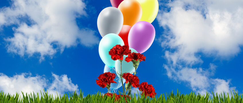 Balloons and flowers create a scene under a bright blue sky with clouds