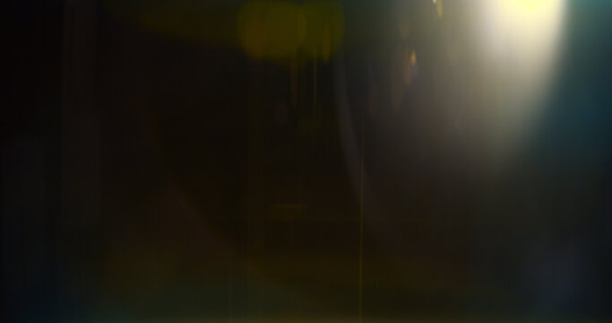 Warm cinematic lens flare overlay featuring golden optical glow, realistic lens reflections and subtle light artifacts on a black background. Premium VFX element for compositing and film editing.