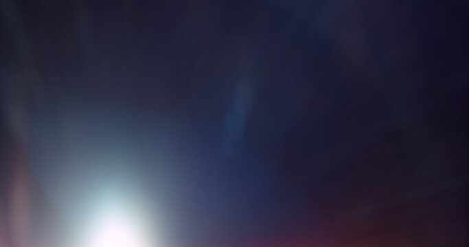 Abstract cinematic lens flare overlay texture featuring soft optical reflections, blue light artifacts and subtle glow on a black background. Premium VFX asset for compositing and film editing.