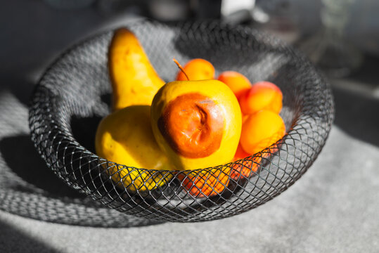 Rotten apple in a fruit basket, close-up