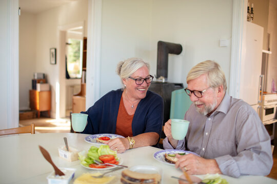 Smiling senior couple eating breakfast at home