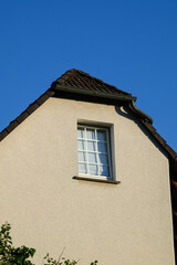 Obraz premium Gable end of a residential house with window textured wall and tiled roof