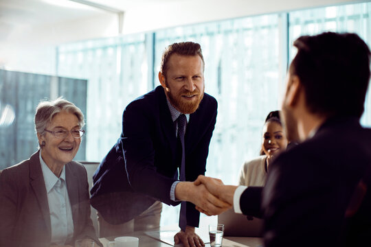 Business colleagues shaking hands in modern office meeting