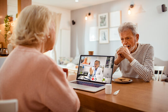 Senior couple having virtual doctor consultation at home
