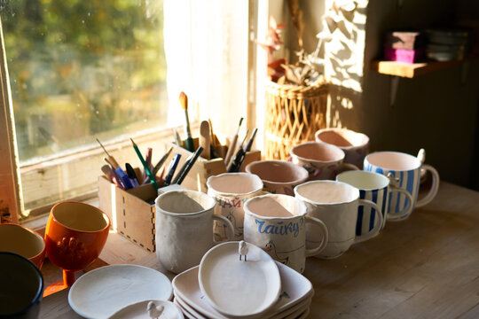 Handmade ceramic mugs drying in pottery studio
