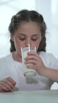 Child drink milk, healthy lifestyle moment. Young girl sipping milk, nourishing drink. Child drinking milk, focus on health and growth. Youngster relishes milk, essential for strong bones