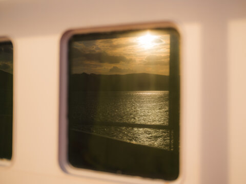 Sunset reflects in the window of a ferry boat 
