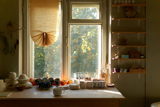 Sunny pottery studio with kiln and worktable
