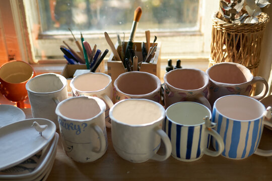 Handmade ceramic mugs drying in pottery studio
