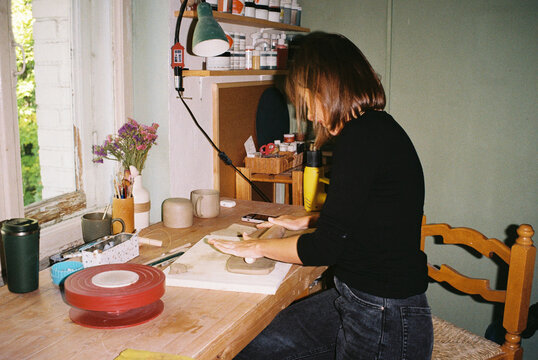 A ceramicist smooths raw clay with her bare hands