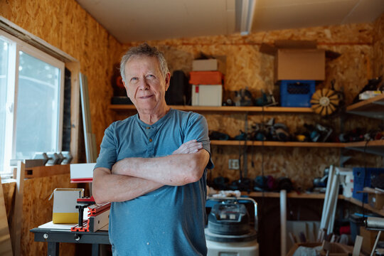 Candid portrait of a smiling craftsman in his woodworking shop