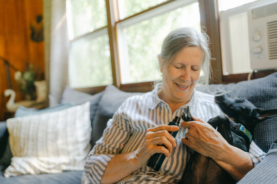 woman trimming nails of her dog 