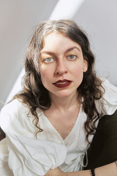 Girl in a studio looking directly at the camera with natural light