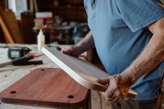 Carpenter shaping wooden board by hand in rustic workshop