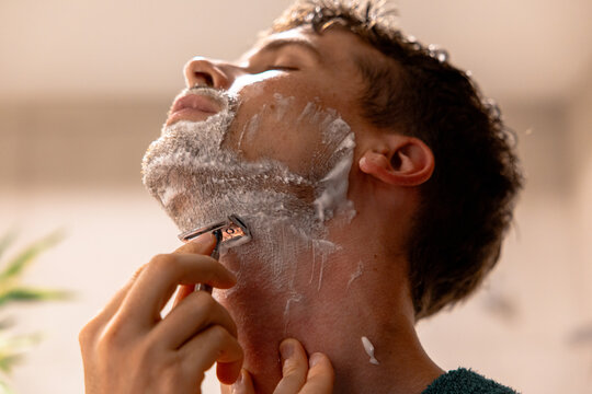 Man shaving his beard in the bathroom