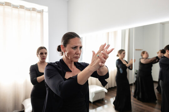 Woman practicing flamenco dance hand movements in studio