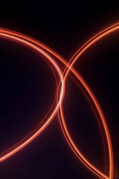 Abstract red light trails on black background. Glowing neon curves in long exposure.