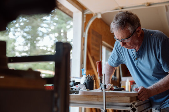 Candid carpenter working in workshop on woodworking project