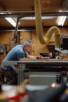 Candid carpenter working on a wood project in workshop