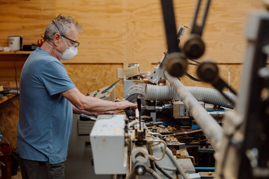 Candid woodworker operating lathe in workshop