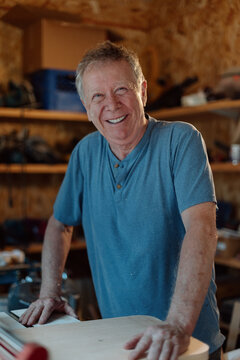 Smiling older man working in workshop, candid and happy