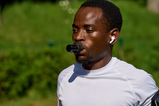 Man Runs Wearing Earbuds and Breathing Mouthpiece During Exercise
