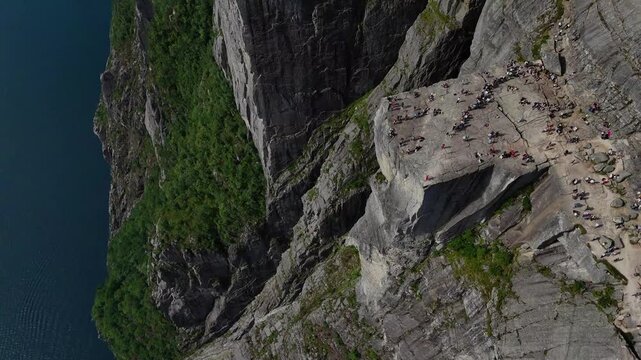 Preikestolen, Norway - 17.07.2026: Aerial view of hikers on Pulpit Rock overlooking Lysefjord, with dramatic cliffs and rugged Scandinavian landscape.