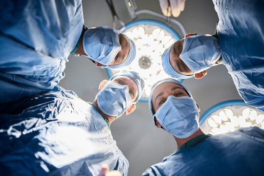 Surgeons gathered under bright operating lights.