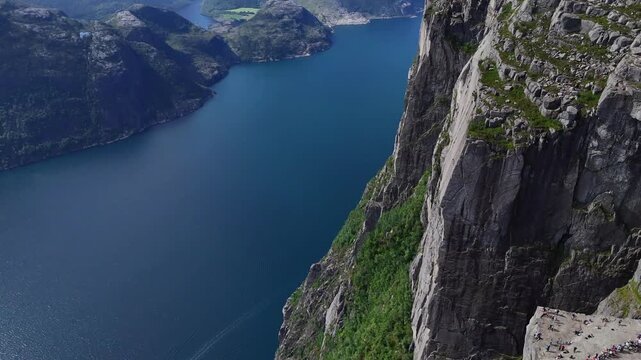 Rogaland, Norway - 17.07.2026: Aerial view of Preikestolen plateau and steep granite cliffs towering above Lysefjord with hikers visible on the rock.
